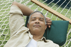 A man naps in a hammock due to the quiet Robomow motor